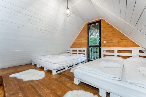 a attic room with two beds and a window at Wellness chata Sloupnice in Sloupnitz
