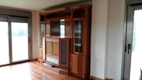 a large wooden cabinet with glass doors in a room at Chalet en Somió con finca independiente in Gijón