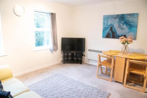 a living room with a table and a television at Lovely 1 bedroom Apartment High Wycombe in Buckinghamshire