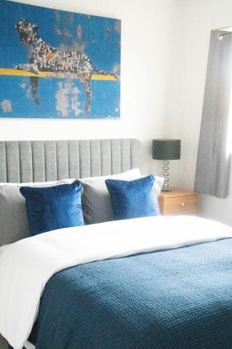a bedroom with a large bed with blue pillows at Lovely 1 bedroom Apartment in Central High Wycombe in Buckinghamshire