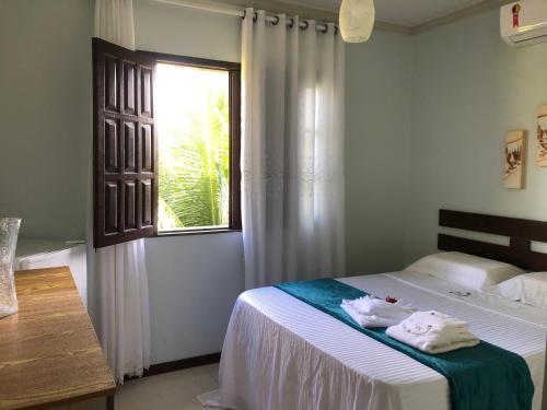 a bedroom with a bed with towels on it at Pousada Carvalhos - Camaçari in Camaçari