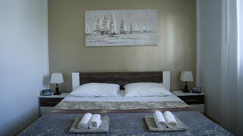 a bedroom with a bed with two towels on it at Apartments Bazina in Kaštela