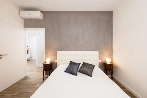 卡迪拉瓦尼亞的住宿－Gomitolo di mare，一间卧室配有一张带两盏灯的大型白色床。