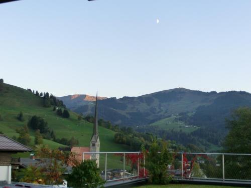 a steeple of a church with mountains in the background at Bergleben Maria Alm - Haus Panorama in Maria Alm am Steinernen Meer