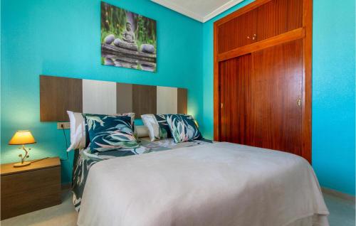 een slaapkamer met een bed en een blauwe muur bij Amazing Apartment In Los Narejos With Kitchen in Los Narejos