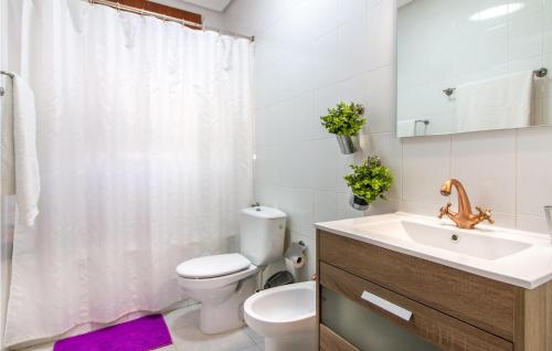 een witte badkamer met een toilet en een wastafel bij Amazing Apartment In Los Narejos With Kitchen in Los Narejos