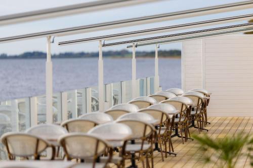 a row of tables and chairs on the deck of a boat at Hørby Færgekro in Holbæk