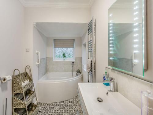 een witte badkamer met een bad en een wastafel bij Featherstone House in Heighington