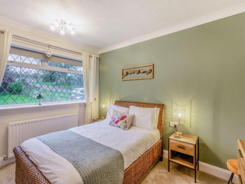 a bedroom with a bed with a window and a table at Featherstone House in Heighington