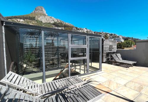 a patio with two benches and a building with windows at Namaste in Cape Town