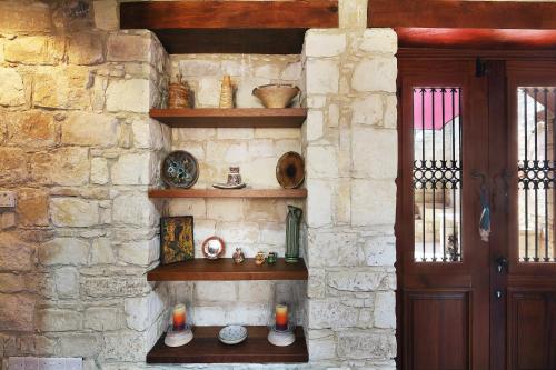 a stone wall with shelves next to a door at KANTARA HOUSE - A Rural Retreat of Comfort & Class! in Arsos