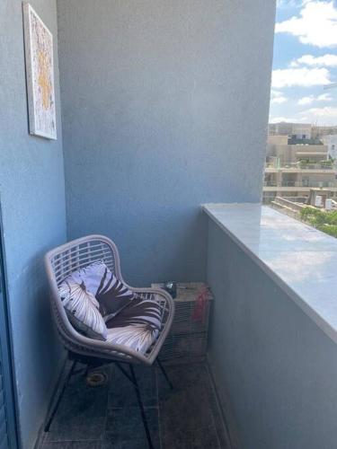 a wicker chair with a pillow sitting on a balcony at Stunning four bedroom duplex in central Raanana in Ra‘ananna