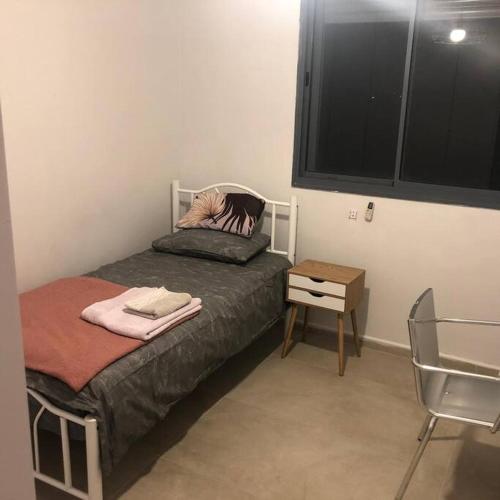 a small bedroom with a bed and a table at Stunning four bedroom duplex in central Raanana in Ra‘ananna