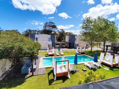 a backyard with a swimming pool and lawn chairs and a swimming poolvisor at Las Martinas Piriapolis in Piriápolis