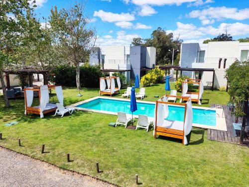 a backyard with a pool with chairs and a table at Las Martinas Piriapolis in Piriápolis