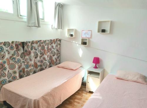 - une chambre avec 2 lits et une lampe rose dans l'établissement Casa Alegre Estepona, à Estepona