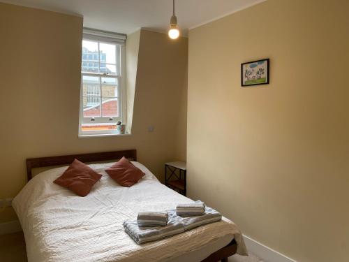 a bedroom with a bed with two towels on it at Penguin Flat in London