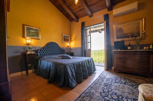 a bedroom with a bed with a blue bedspread on it at Villa Bricco dei Cogni in La Morra