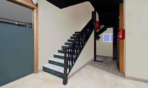 a staircase in a house with a black railing at Treebo Maharaja Residency in Jaipur