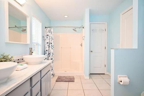 La salle de bains est pourvue de 2 lavabos et d'une douche. dans l'établissement Cozy family vacation with large pool near Disney, à Davenport