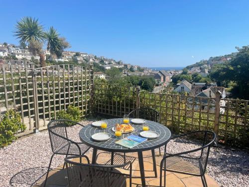 a table and chairs on a patio with a view at Sea View House in Cornwall Fishing Village in St Austell
