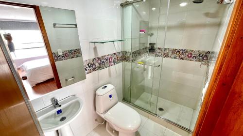 een badkamer met een toilet, een wastafel en een douche bij HOTEL HOME in Pasto