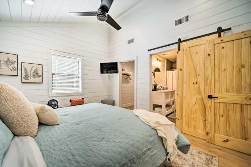 een slaapkamer met een bed en een plafondventilator bij A Little Bit of Simple Cabin with Pond Access in Broken Bow