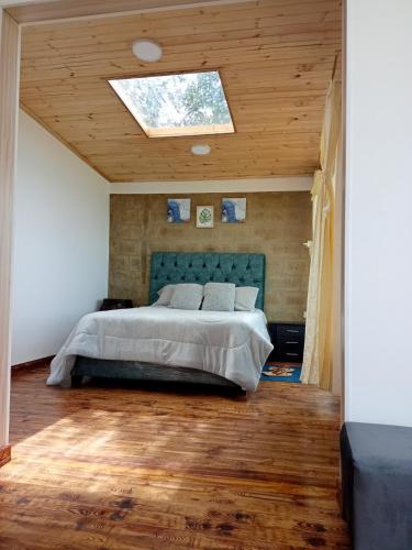 a bedroom with a bed and a skylight at Cabañas el Olimpo in Aquitania