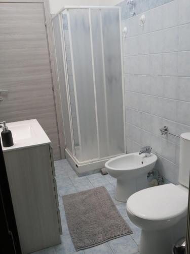 a bathroom with a toilet and a sink and a shower at Focu e Mari in Mascali