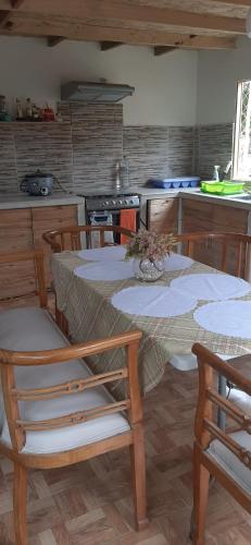 a kitchen with a table and chairs and a kitchen with a stove at Cabaña VILLA ANGÉLICA-LUNAHUANA in Lunahuaná