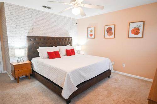ein Schlafzimmer mit einem großen Bett mit roten Kissen in der Unterkunft Disney Home + Private Pool in Davenport