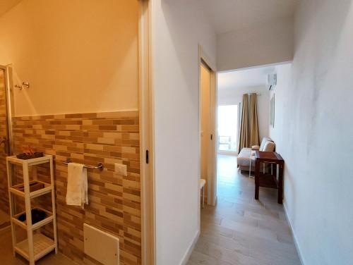 a hallway with a bathroom with a brick wall at Casa Alexandra in Castelsardo