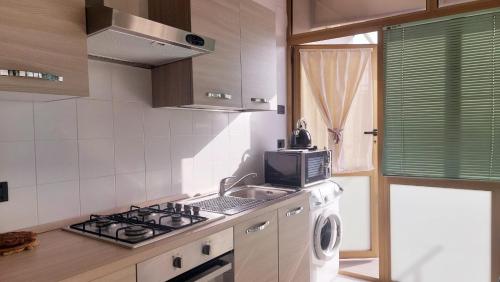 una cucina con piano cottura e lavatrice di Attico trilocale con solarium a Borghetto Santo Spirito a Borghetto Santo Spirito