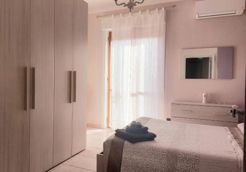1 dormitorio con 1 cama, vestidor y ventana en Attico trilocale con solarium a Borghetto Santo Spirito, en Borghetto Santo Spirito
