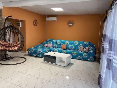 - un salon avec un canapé bleu et une table dans l'établissement Logement 2 chambres au sud de Mayotte, à Bouéni
