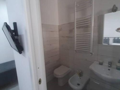 a white bathroom with a toilet and a sink at Albergo Abruzzese in Riano