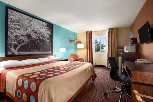 a hotel room with a bed and a desk at Super 8 by Wyndham Marion in Marion