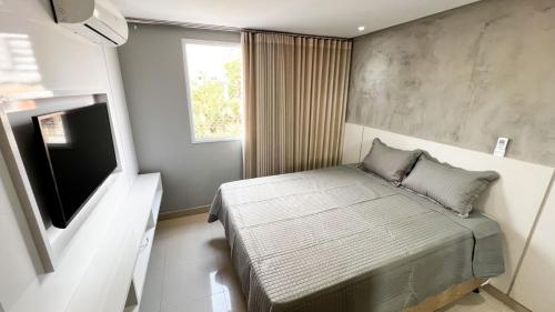 a small bedroom with a bed and a television at The Expression 112 in Goiânia