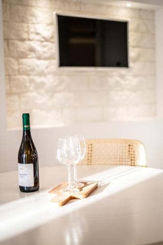 a bottle of wine and a glass on a table at DIMORA PALASCIANO in Alberobello