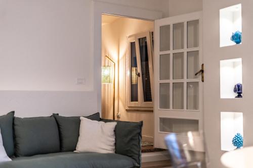 a living room with a blue couch and a mirror at DIMORA PALASCIANO in Alberobello