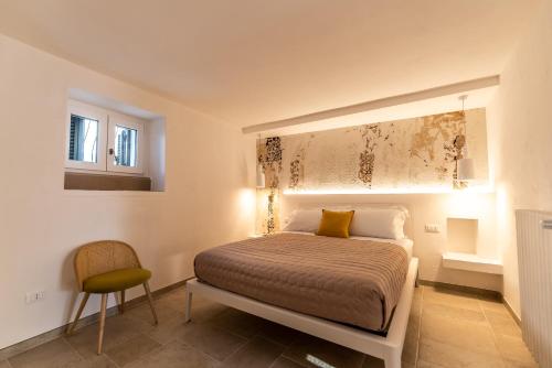 a bedroom with a bed and a chair in it at DIMORA PALASCIANO in Alberobello