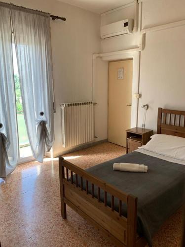 Un dormitorio con una cama y una ventana grande. en Albergo Abruzzese, en Riano