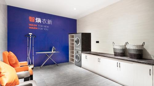 Holiday Inn Express Cangzhou High-Tech Zone, an IHG Hotel في Cangzhou: غرفة غسيل مع غسالة ومجفف