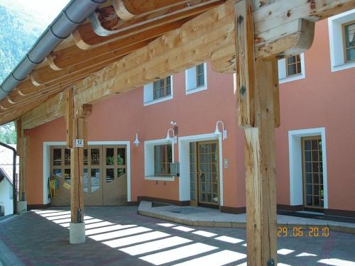 un gran edificio rosa con pérgola de madera en Appartement beim Brunnen 12, en Sölden