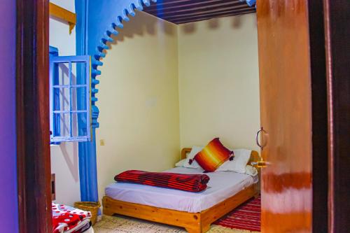 ein Schlafzimmer mit einem Bett mit einem Bogen darüber in der Unterkunft Cordoba Pension in Chefchaouen