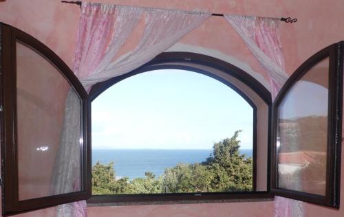 a view from a window of a balcony overlooking the ocean at La Finestra Vista Corsica in Santa Teresa Gallura