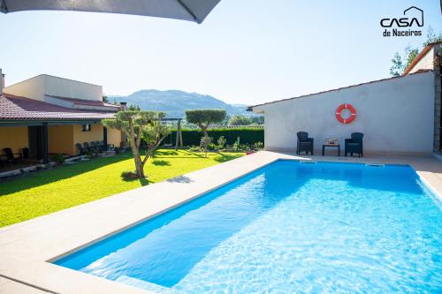 a swimming pool in the backyard of a house at Casa de Naceiros - Ponte de Lima in Viana do Castelo