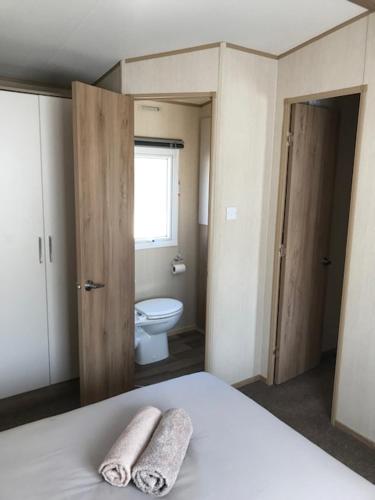 a bedroom with a bed and a bathroom with a toilet at Summer Breeze in Aviemore