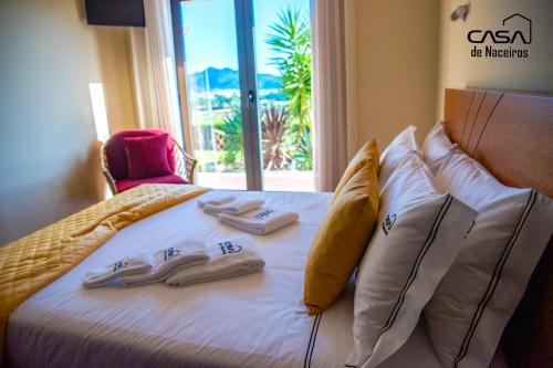 ein Bett mit zwei Paar Hausschuhen drauf in der Unterkunft Casa de Naceiros - Ponte de Lima in Viana do Castelo