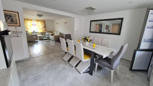 a dining room and living room with a table and chairs at Carpe Diem Lakeside Apartment in Szczecin
